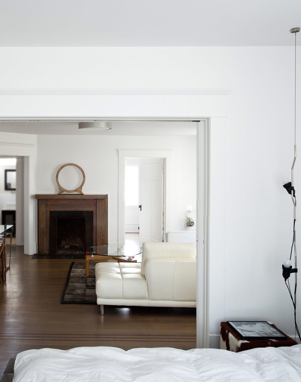 Kitsilano House — View through a doorway towards a sitting room fireplace
