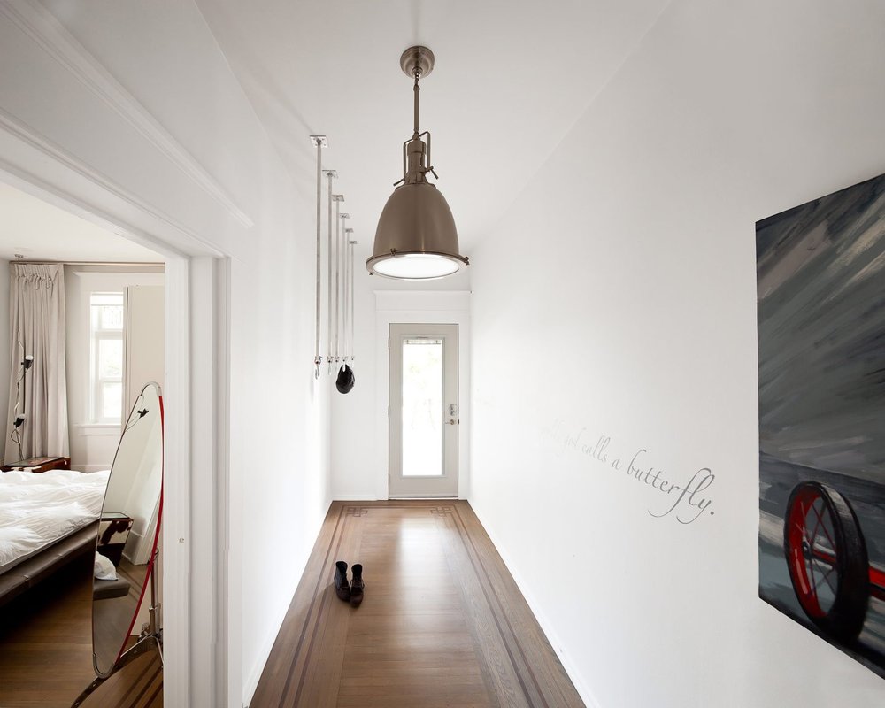 Kitsilano House — White corridor with timber flooring and pendant light