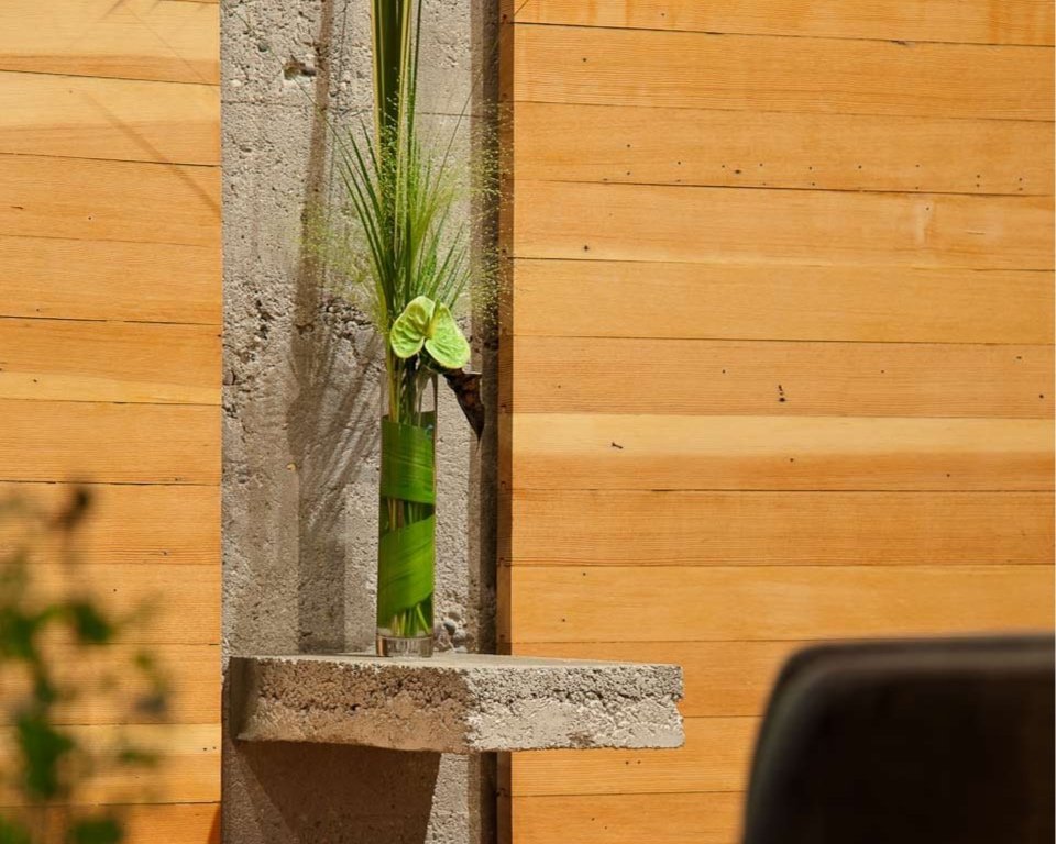 Espresso Lounge — Flower arrangement against a concrete column and timber panels
