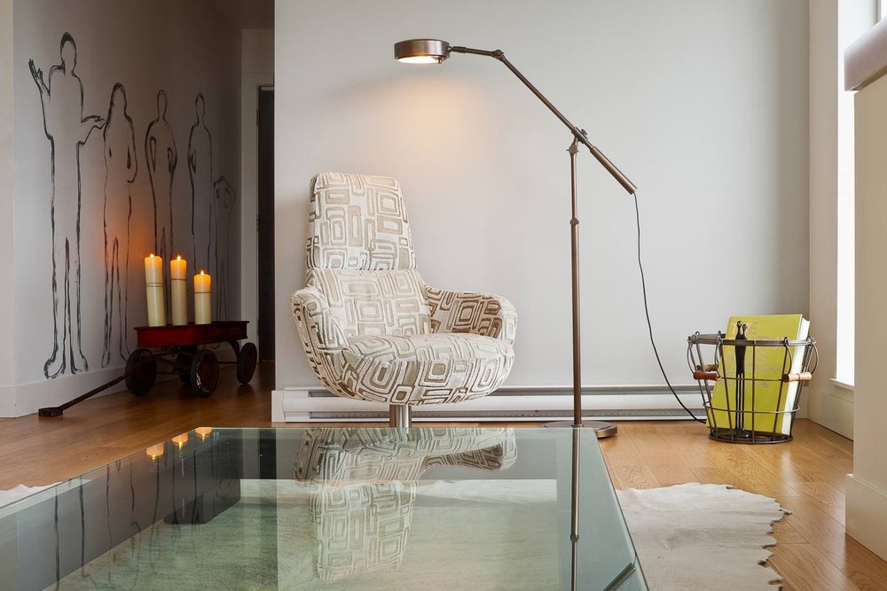 City Retreat — Glass coffee table, patterned armchair and angled floor lamp