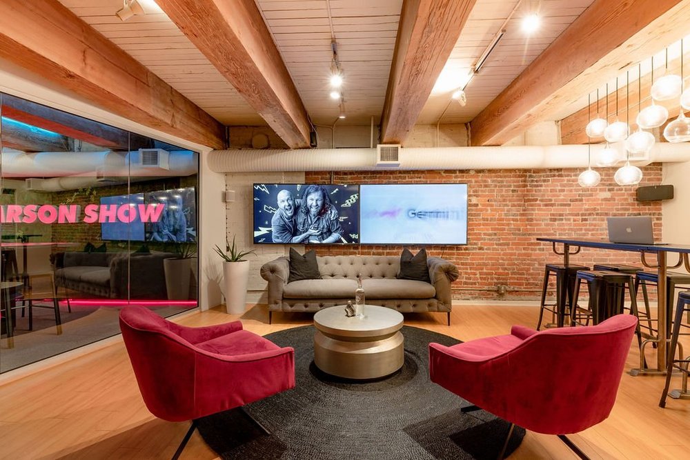 Podcast Studio — Red lounge chairs and sofa beneath exposed timber beams