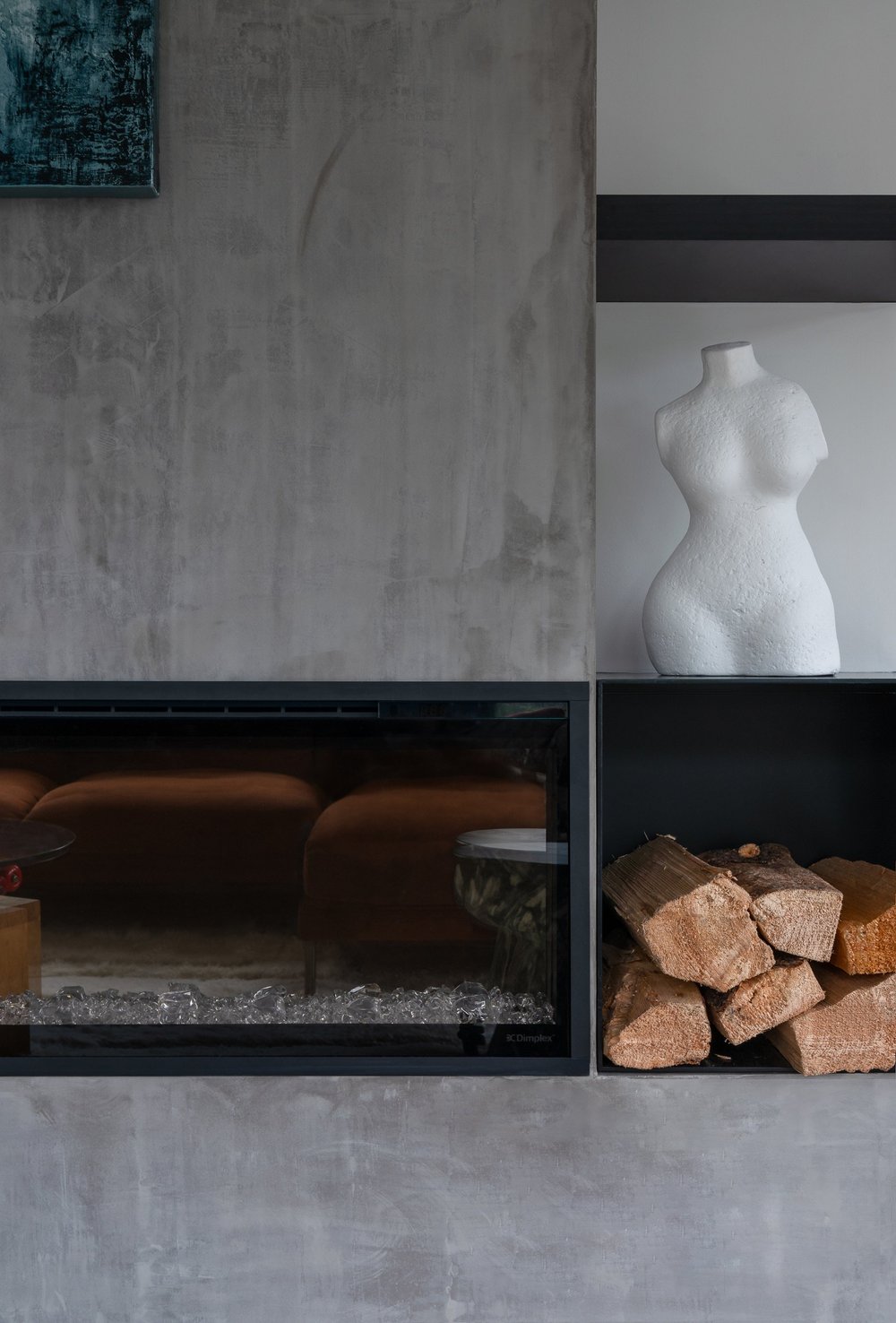 Britannia Beach House — Concrete fireplace with recessed log storage and white ceramic sculpture