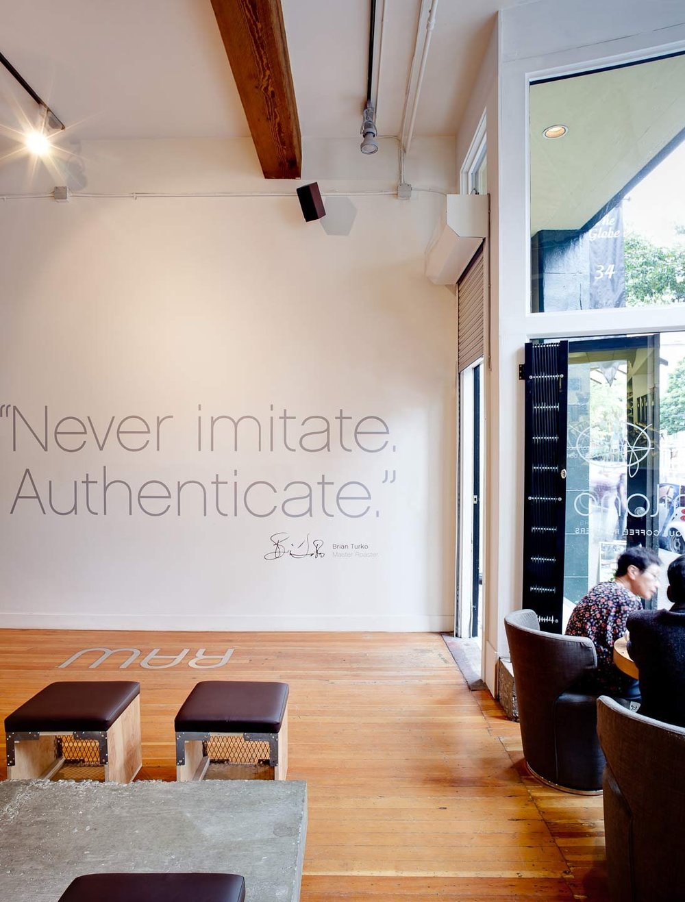 Espresso Lounge — Seating beside a tall window and typographic wall